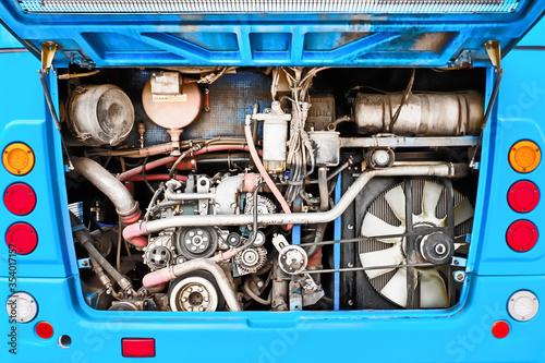 bus engine compartment open for repair. Back side close up view of motor for city coach. Vehicle mechanical gear parts technical maintenance