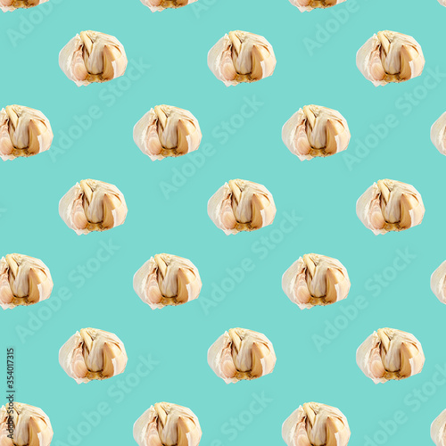 Seamless pattern with garlic on a blue background. Minimal isometric texture of food. Use for boards, print on fabric.