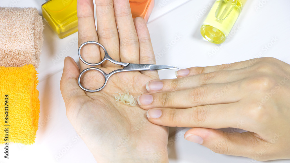 Manicure. A woman holds a cutoff nails in her hand. Cut your