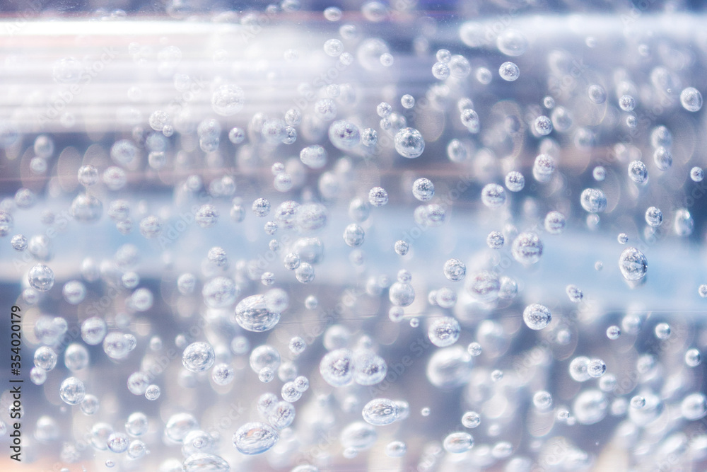 Transparent bubbles in the gel liquid. Light blue background with bubbles