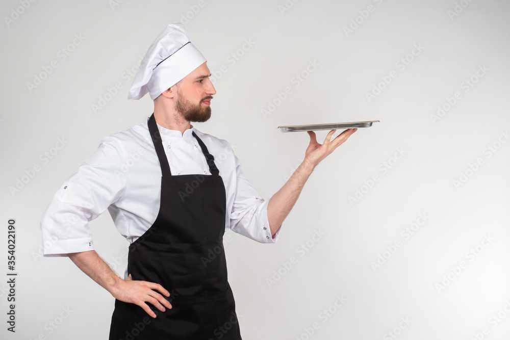 Chef recommended. Chef cook dressed in uniform holding an empty tray. Cook shows finished dish. Tray in hands of a young cook. Food. Culinary specialist. Concept - presentation of the restaurant menu Chef recommended. Chef cook dressed in uniform holding an empty tray. Cook shows finished dish. Tray in hands of a young cook. Food. Culinary specialist. Concept - presentation of the restaurant menu