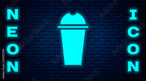 Glowing neon Milkshake icon isolated on brick wall background. Plastic cup with lid and straw. Vector Illustration.