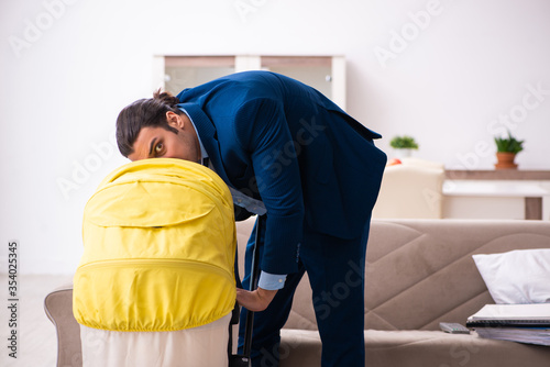 Young businessman looking after newborn at home