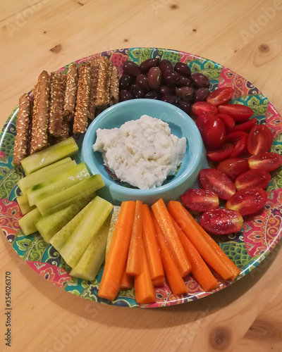 party platter with different kinds of vegetables and cheese salad on a colorful plate 