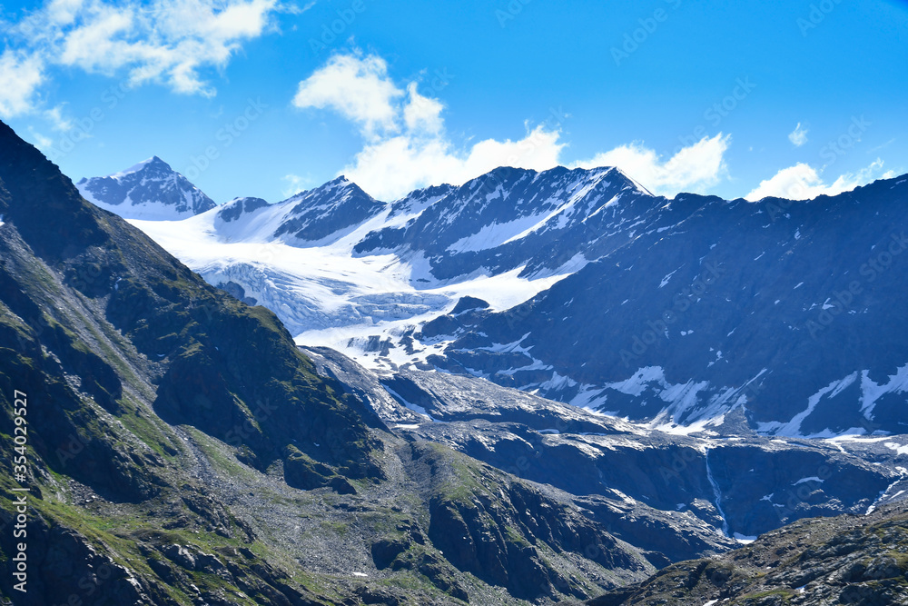 Summer mountain landscape with blue sky and snow.