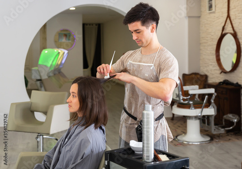 Man applying dye to womans hair in salon