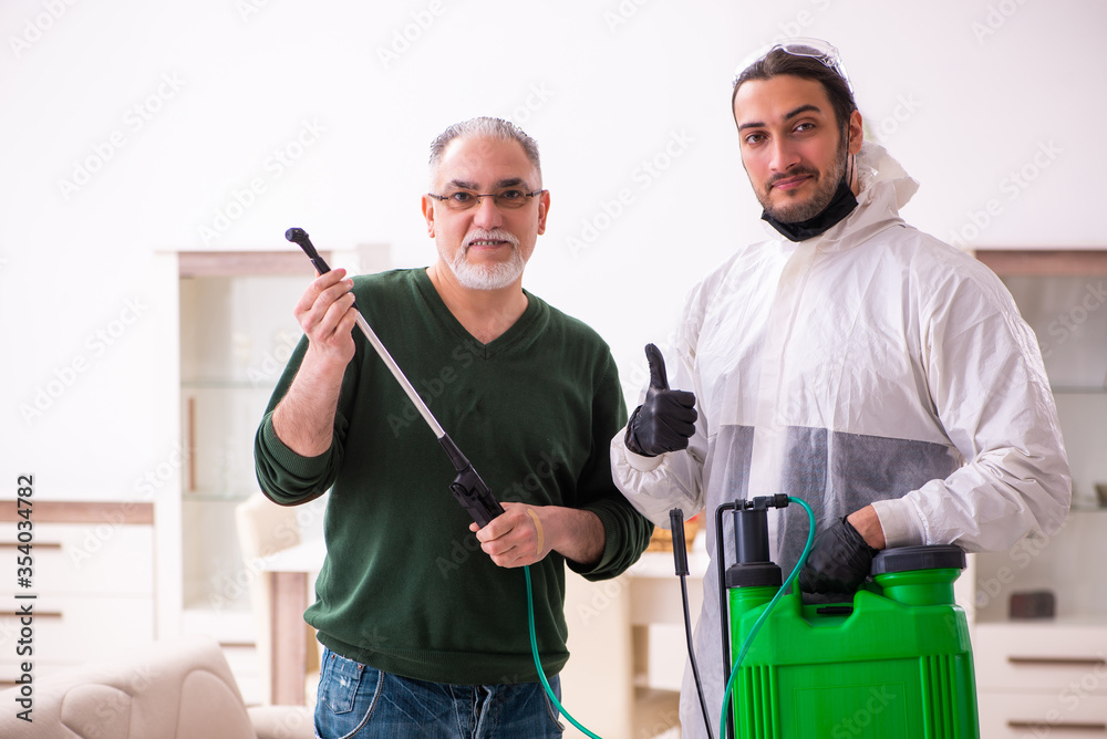 Young male sanitizer and old man indoors Young male sanitizer and old man indoors