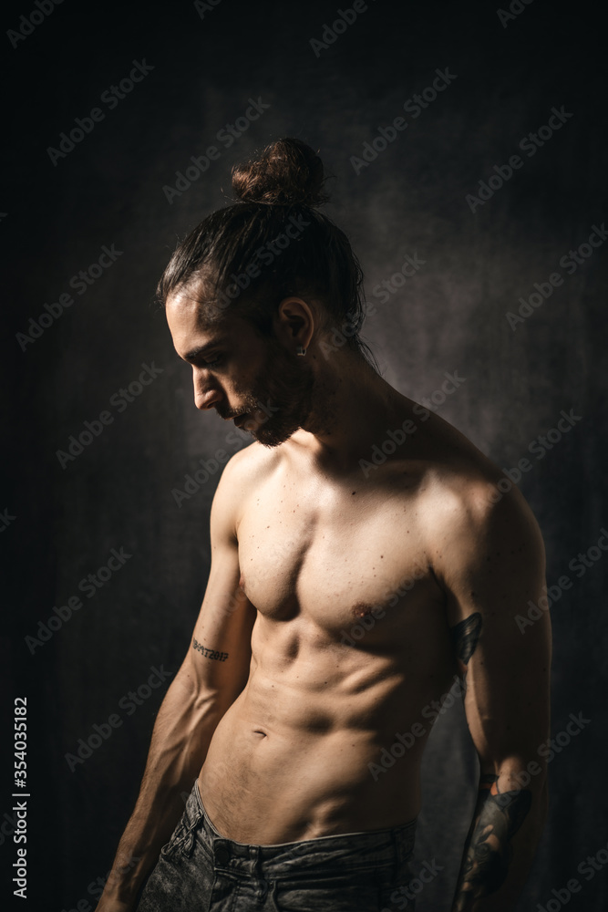 Fototapeta premium Modelo de cuerpo atlético, masculino, en fondo oscuro