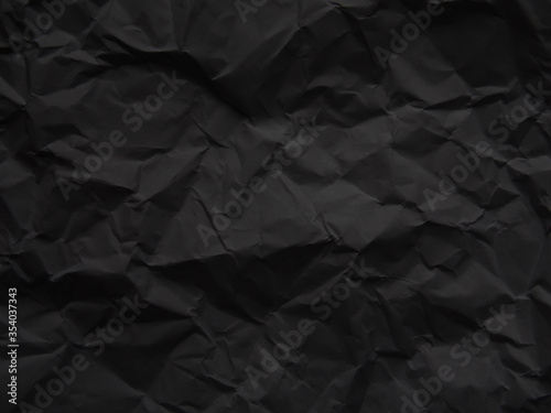 Black crumpled paper. Dark grunge texture background