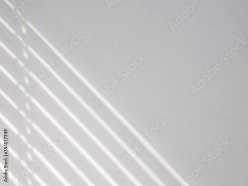 Diagonal highlights from blinds on white wall background