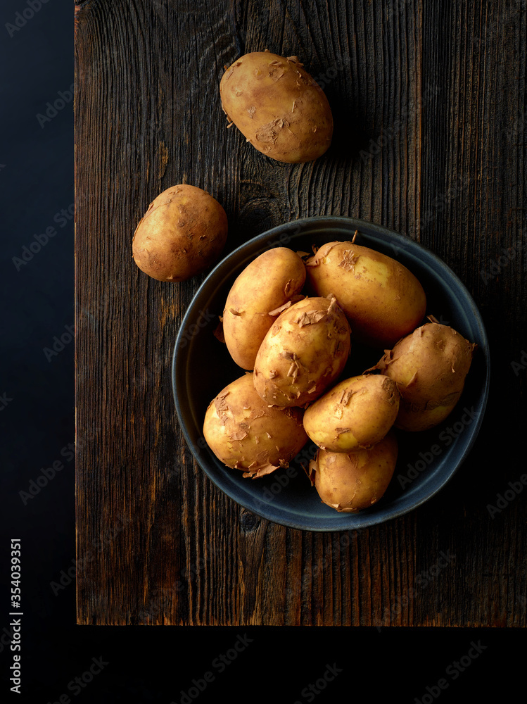 Bowl of potatoes on black background, top view Bowl of potatoes on black background, top view