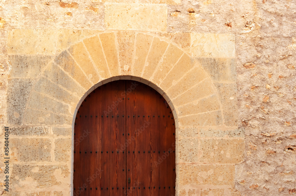 Stone facade with wooden door and stone arch of popular architecture Stone facade with wooden door and stone arch of popular architecture