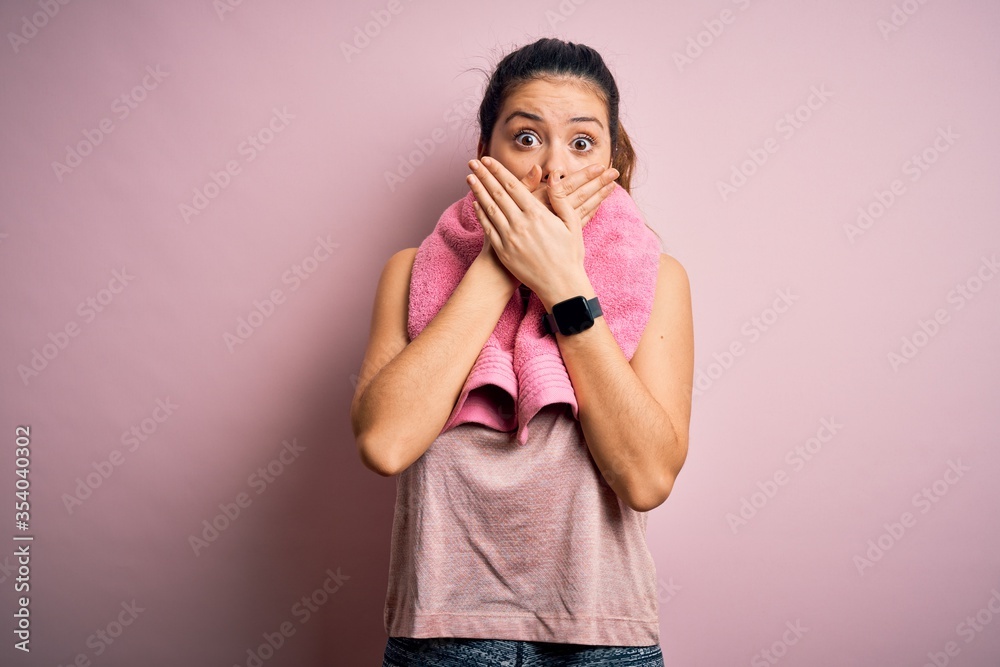 Φωτογραφία Young beautiful brunette sportswoman wearing sportswear and towel over pink background shocked covering mouth with hands for mistake