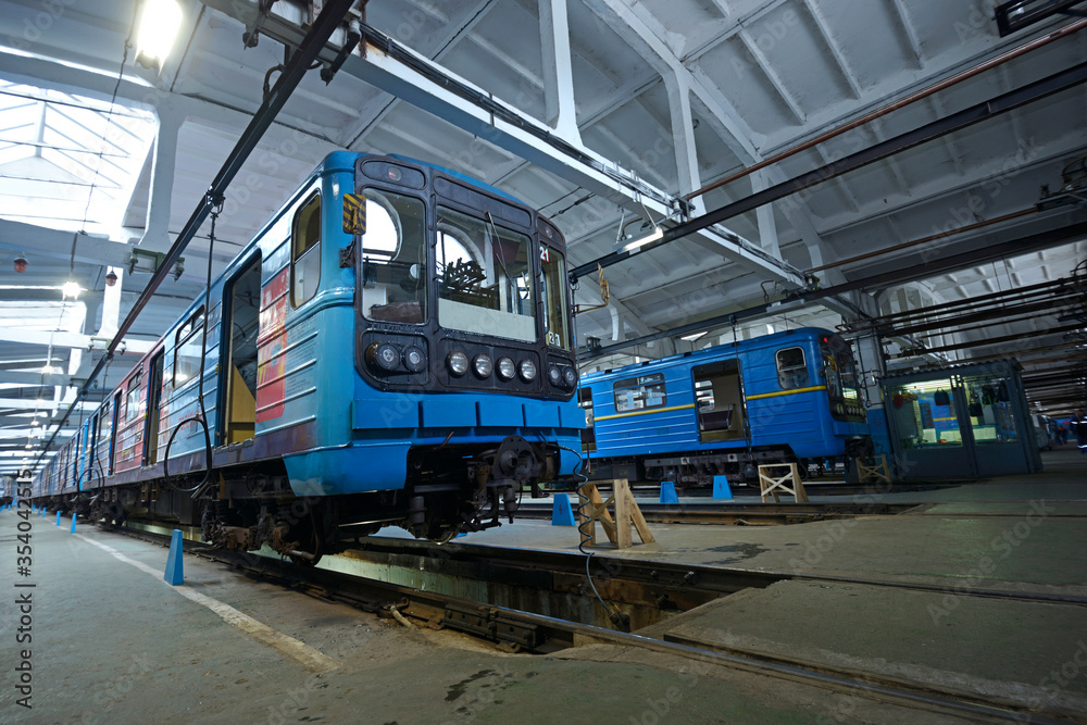 Fototapeta premium At the maintenance hall: subway trains parked on pits for technical inspection