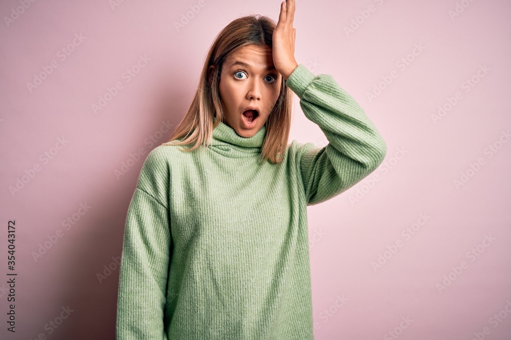 Young beautiful blonde woman wearing winter wool sweater over pink isolated background surprised with hand on head for mistake, remember error. Forgot, bad memory concept. Young beautiful blonde woman wearing winter wool sweater over pink isolated background surprised with hand on head for mistake, remember error. Forgot, bad memory concept.