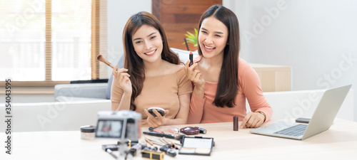 Two young beautiful asian woman professional beauty vlogger or blogger recording make up tutorial to share on social media 