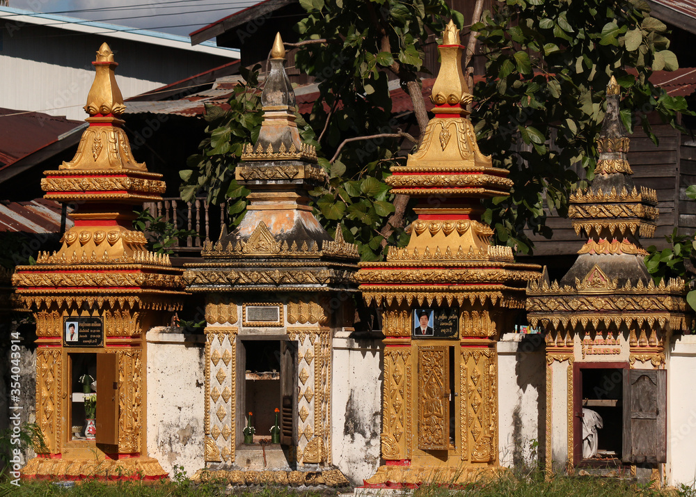 Examples of monks graves in stupa design situated at along the temple wall in Siamese Lao PDR, Southeast Asia Examples of monks graves in stupa design situated at along the temple wall in Siamese Lao PDR, Southeast Asia