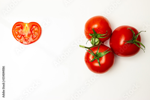 ripe, juicy, red tomatoes and a cut of tomato on a white background © Виталий Мазур