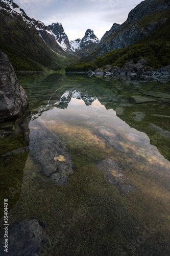 Emily peak reflecting in McKenzie lake at sunset, Routeburn track, South Island, New Zealand photo