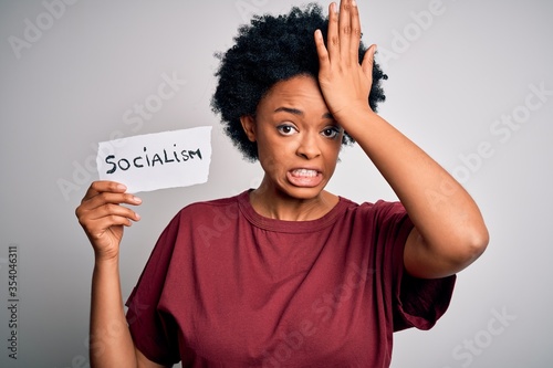 Young African American afro politician woman with curly hair socialist party member stressed with hand on head, shocked with shame and surprise face, angry and frustrated. Fear and upset for mistake. photo