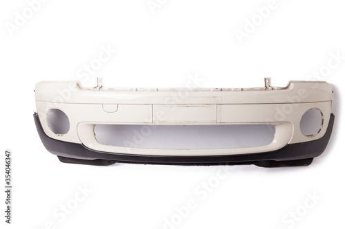 Photos White car bumper with a black plastic panel on an isolated background, part for installation on a car body after repair and painting during repair in a workshop