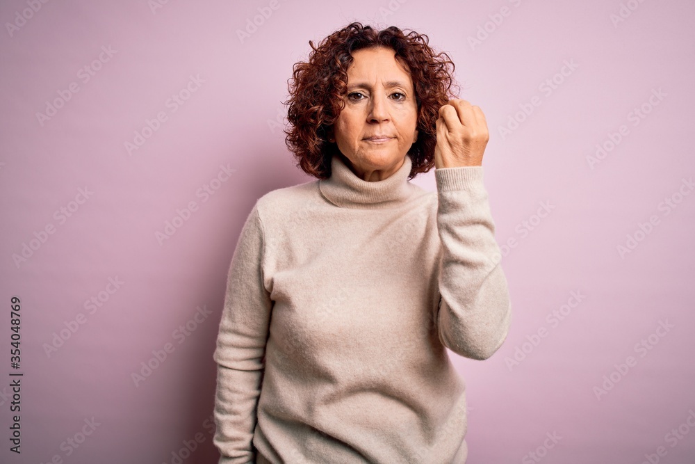 Middle age beautiful curly hair woman wearing casual turtleneck sweater over pink background Doing Italian gesture with hand and fingers confident expression Middle age beautiful curly hair woman wearing casual turtleneck sweater over pink background Doing Italian gesture with hand and fingers confident expression