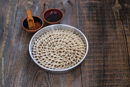 traditional tray ravioli with pepper on wooden background. 