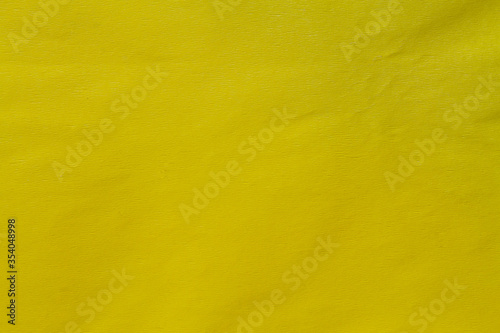 background from crumpled yellow color crepe paper close up