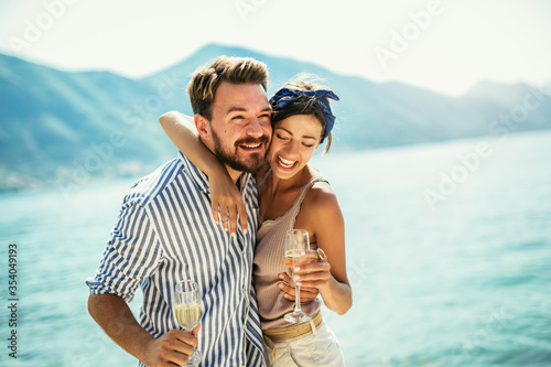Young couple with wine having romantic date on the beach
