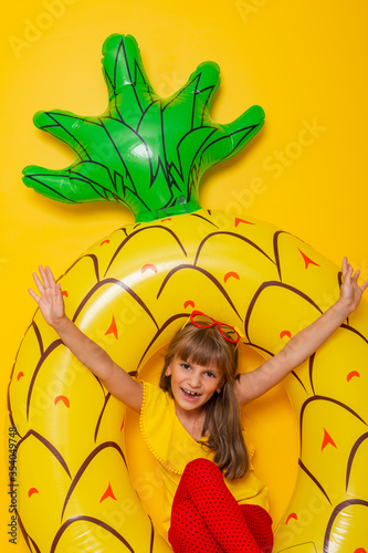 Child sitting in an inflatable pineapple shaped swim ring