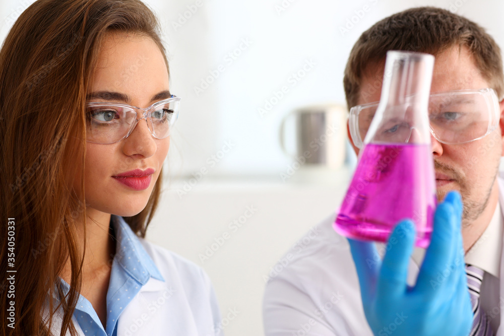 Technician hold in arms in protective gloves sample bottle Technician hold in arms in protective gloves sample bottle