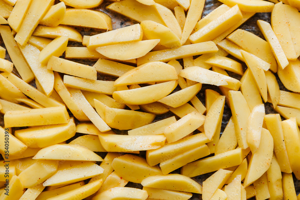 Sliced potatoes are laid out on a baking sheet and ready to be baked. Sliced potatoes are laid out on a baking sheet and ready to be baked.