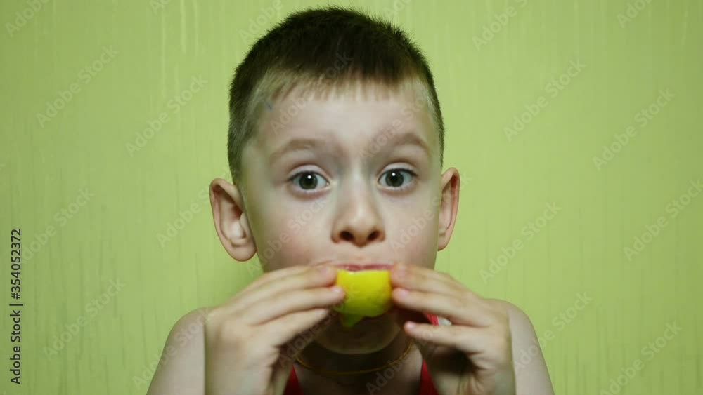 Close up of a cheerful caucasian boy tasting fresh lemon. Close up of a cheerful caucasian boy tasting fresh lemon.