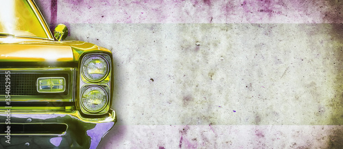 Headlight of an old beautiful yellow car on a concrete wall background. Copy space concept for repair banners, car sale.
