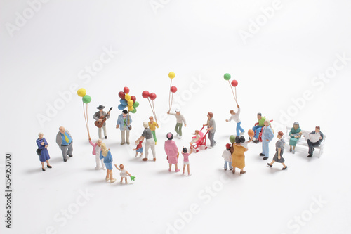 a mini people with family holding balloon on the board photo