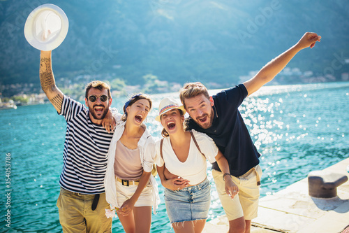 Group of friends having fun near the sea on vacation