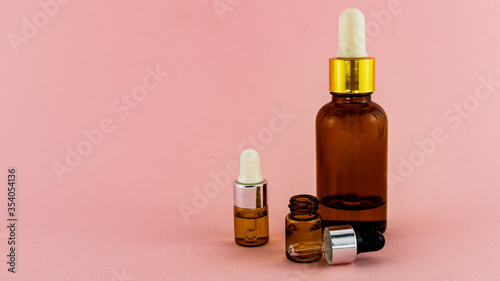 a small bottle of oil for skin care on a pink background