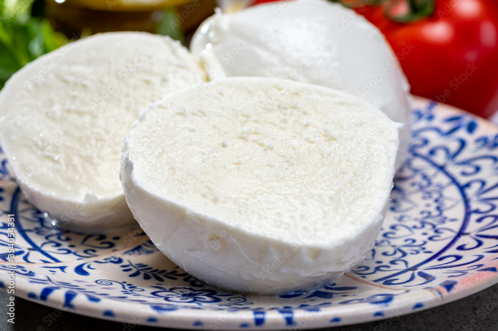 Fresh handmade soft Italian cheese from Campania, white balls of buffalo mozzarella cheese made from cow milk ready to eat Fresh handmade soft Italian cheese from Campania, white balls of buffalo mozzarella cheese made from cow milk ready to eat