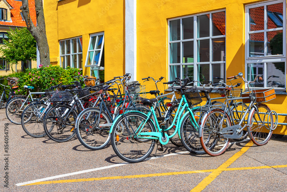 Many bicycles parked in front of a yellow house. Copenhagen. Denmark. Bicycles are one of the main means of transportation ..