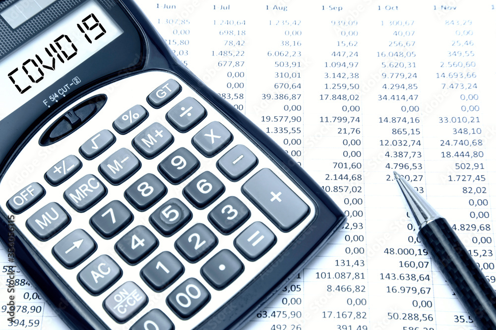 Covid 19 digital text on calculator screen, with budget sheet background Covid 19 digital text on calculator screen, with budget sheet background