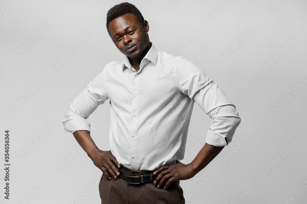 Obraz premium Handsome black african puts his hands on his hips. Business portrait in studio on white background. Online business.