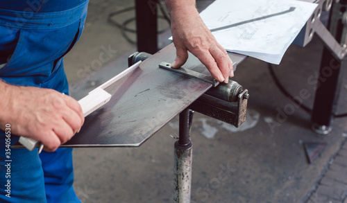 Metalworker measuring a strip of steel photo