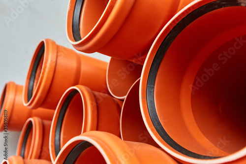 Orange plastic pipes lie in rows