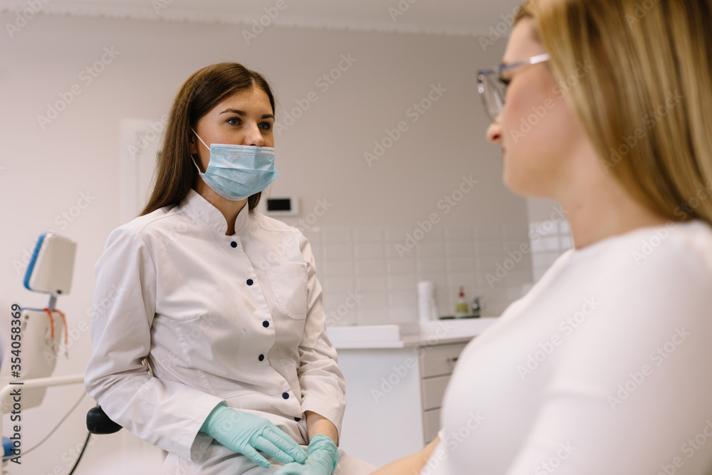 Dentist looking on pregnant woman's teeth using mirror Dentist looking on pregnant woman's teeth using mirror