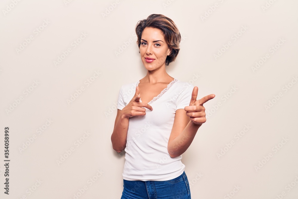 Young beautiful woman wearing casual clothes pointing fingers to camera with happy and funny face. good energy and vibes. Young beautiful woman wearing casual clothes pointing fingers to camera with happy and funny face. good energy and vibes.