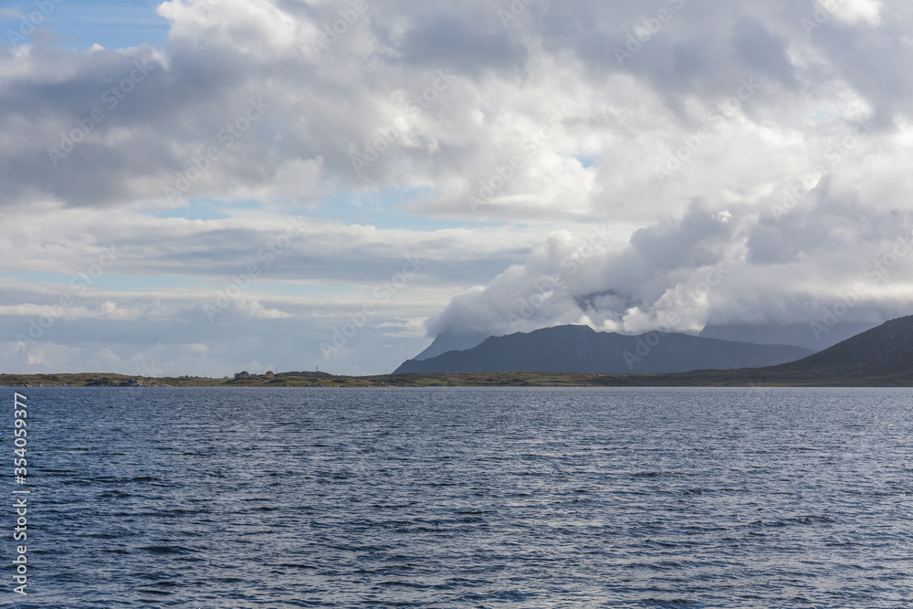 Beautiful view of the Norwegian fjords with turquoise water surrounded by cloudy sky, selective focus Beautiful view of the Norwegian fjords with turquoise water surrounded by cloudy sky, selective focus