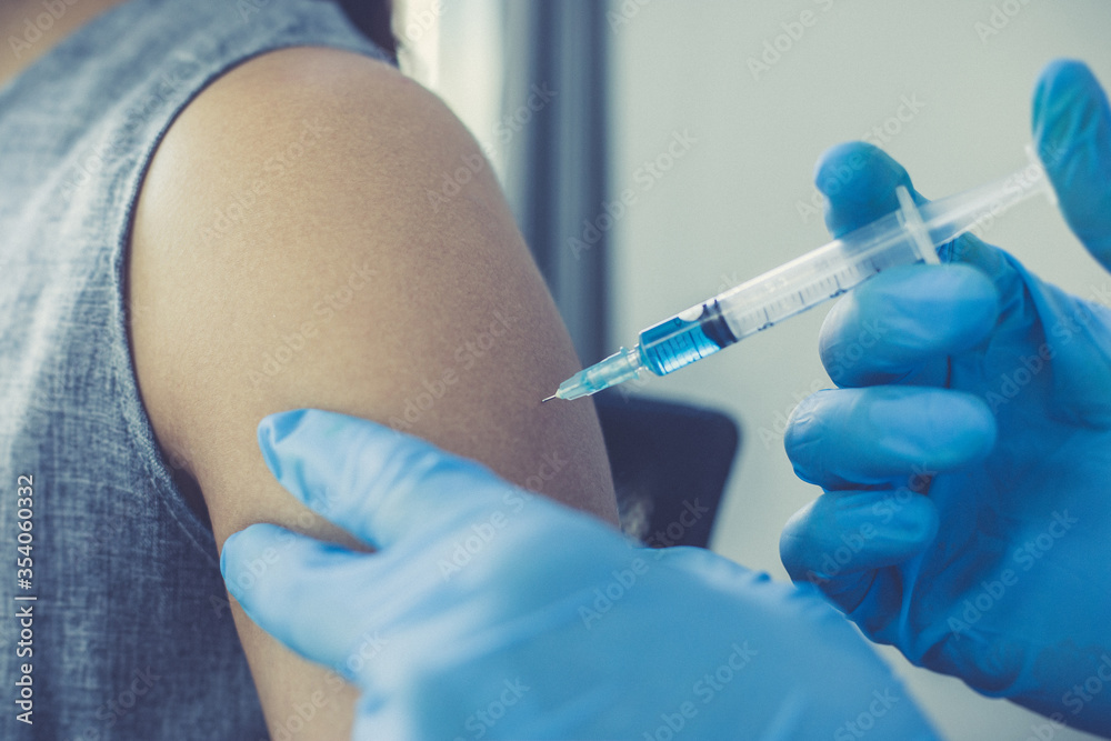 Vaccination of patients, Doctor provided a vaccine with a syringe against a new strain of virus or influenza in a modern hospital, Prevention and health care concept. Vaccination of patients, Doctor provided a vaccine with a syringe against a new strain of virus or influenza in a modern hospital, Prevention and health care concept.