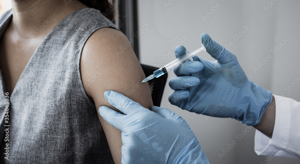 Vaccination of patients, Doctor provided a vaccine with a syringe against a new strain of virus or influenza in a modern hospital, Prevention and health care concept. Vaccination of patients, Doctor provided a vaccine with a syringe against a new strain of virus or influenza in a modern hospital, Prevention and health care concept.