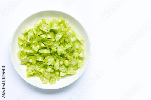Moringa oleifera seeds in white plate isolated on white