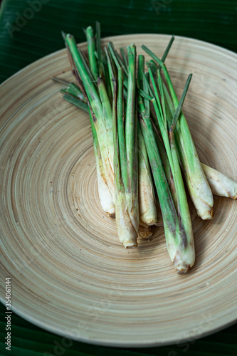 Fresh Lemongrass (Cymbopogon citratus) or citronella, serai on a wooden plate.